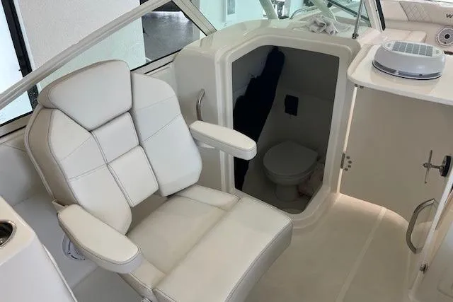 Slide: The Image of 2026 World Cat 230 SD boat interior with white seating and compact restroom. - 14