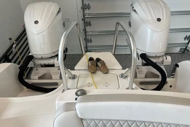 Slide: The Image of 2026 World Cat 230 SD boat with dual engines and shoes on deck in a garage. - 2