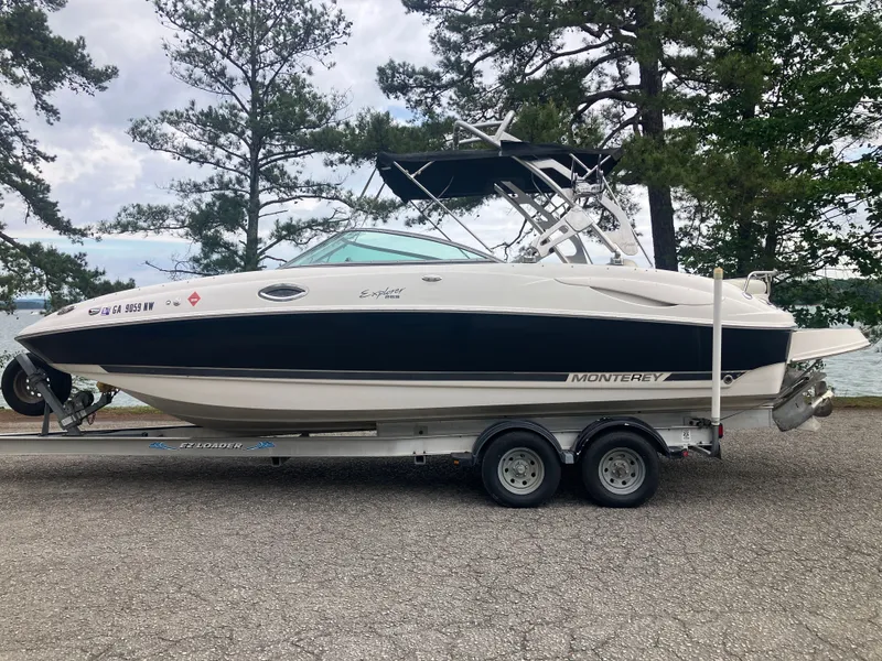 The Image of 2006 Monterey 263 ES boat on trailer, surrounded by trees. - 0