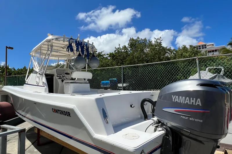 Slide: The Image of 2005 Contender 31 Fisharound boat with Yamaha engine, docked under clear blue sky. - 16
