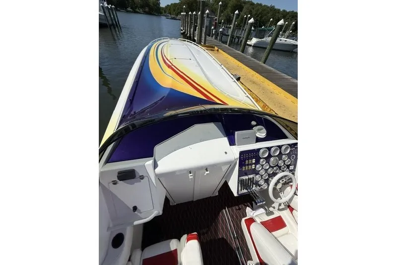 Slide: The Image of 2000 Fountain 47 Lightning boat with colorful deck, docked at marina. - 13