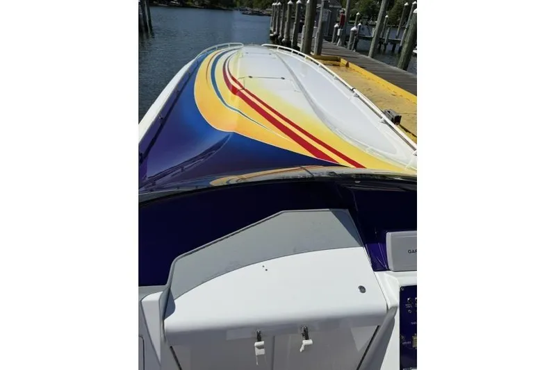 Slide: The Image of 2000 Fountain 47 Lightning boat with vibrant yellow and red stripes docked by the water. - 16
