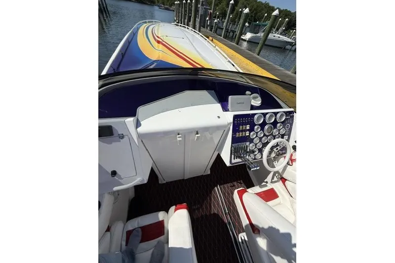Slide: The Image of Cockpit view of a 2000 Fountain 47 Lightning speedboat with vibrant deck design. - 21