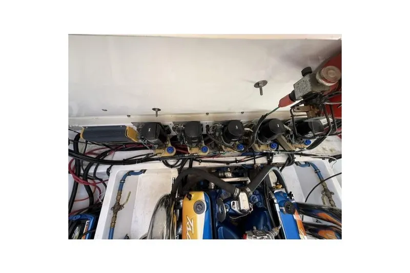 Slide: The Image of Engine compartment of a 2000 Fountain 47 Lightning boat, showcasing mechanical components and wiring. - 24