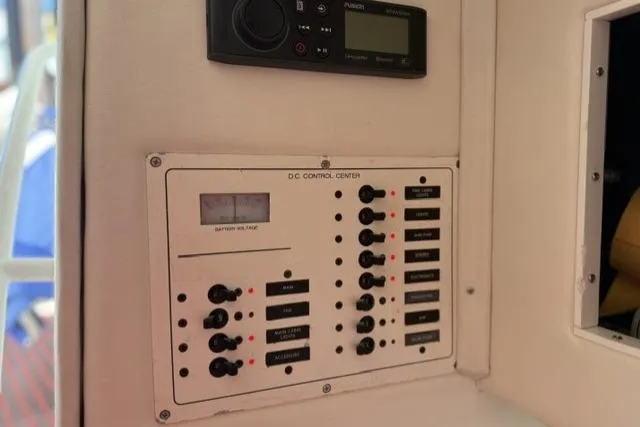Slide: The Image of Control panel of a 2000 Fountain 47 Lightning boat, featuring switches and voltage display. - 31