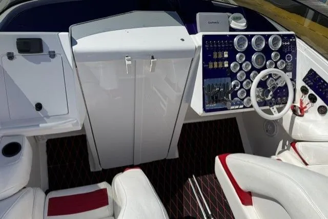 Slide: The Image of Cockpit of a 2000 Fountain 47 Lightning boat with white and red seating, and detailed control panel. - 32