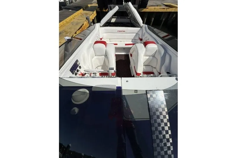 Slide: The Image of 2000 Fountain 47 Lightning speedboat interior with white and red seating at dock. - 36