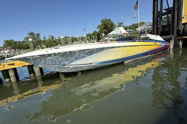 Slide: The Image of 2000 Fountain 47 Lightning speedboat docked, featuring vibrant graphics and sleek design. - 4