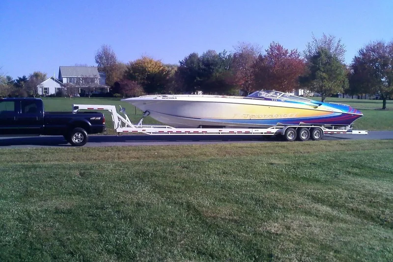 Slide: The Image of Black truck towing a 2000 Fountain 47 Lightning boat on a trailer in a suburban area. - 46