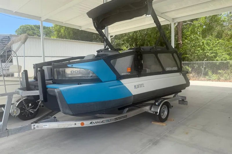 Slide: The Image of 2022 Sea-Doo Switch Sport 18 on trailer, parked under a canopy. - 3