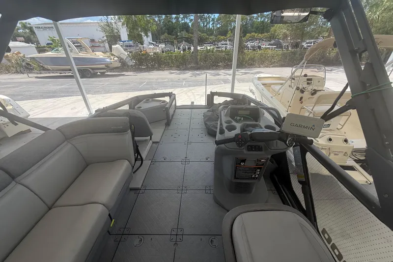 Slide: The Image of 2022 Sea-Doo Switch Sport 18 interior with seating and steering console, docked near other boats. - 6