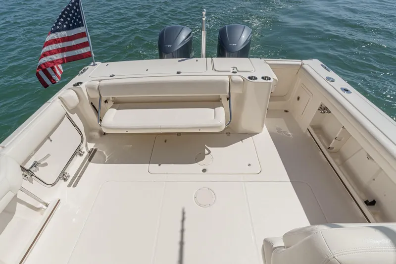 Slide: The Image of 2016 Grady-White Freedom 335 boat deck with seating, American flag, and twin engines. - 16