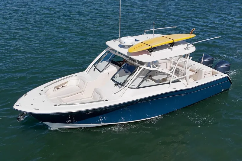 Slide: The Image of 2016 Grady-White Freedom 335 boat cruising on water with a yellow kayak on top. - 2