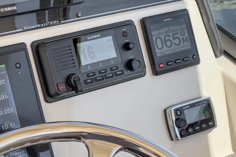 Slide: The Image of Dashboard of 2016 Grady-White Freedom 335 with Garmin navigation and Fusion audio controls. - 24