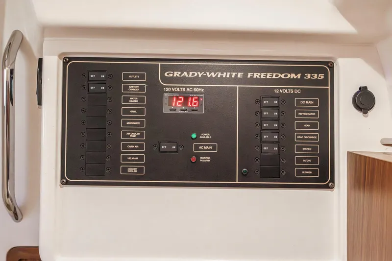 Slide: The Image of Electrical control panel of 2016 Grady-White Freedom 335 boat, featuring AC and DC switches. - 27