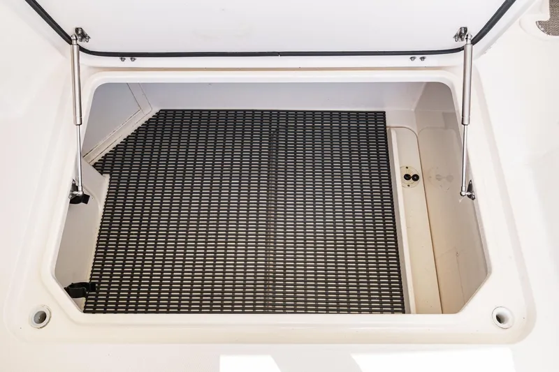 Slide: The Image of Open storage compartment on 2016 Grady-White Freedom 335 boat with black mat. - 29