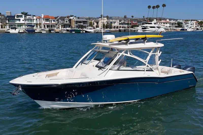 Slide: The Image of 2016 Grady-White Freedom 335 boat on water, with coastal homes in the background. - 3