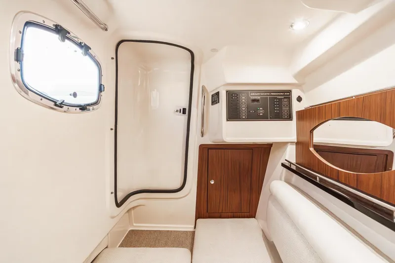 Slide: The Image of 2016 Grady-White Freedom 335 cabin interior with control panel and wooden accents. - 30