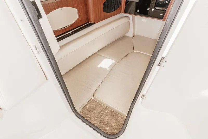 Slide: The Image of Interior cabin of 2016 Grady-White Freedom 335 boat, featuring beige seating and wood accents. - 32