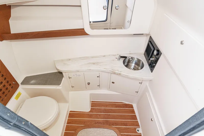 Slide: The Image of 2016 Grady-White Freedom 335 boat interior with sink, toilet, and wooden flooring. - 34