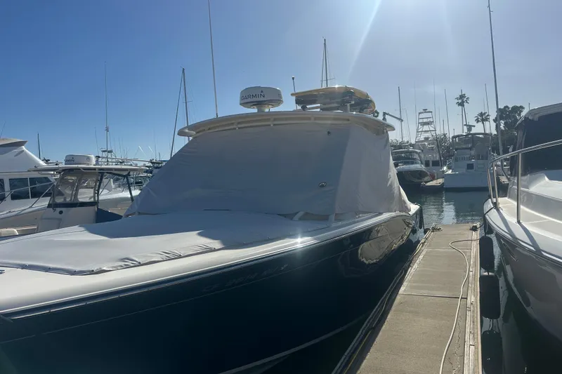 Slide: The Image of 2016 Grady-White Freedom 335 boat docked in a marina under clear blue sky. - 36