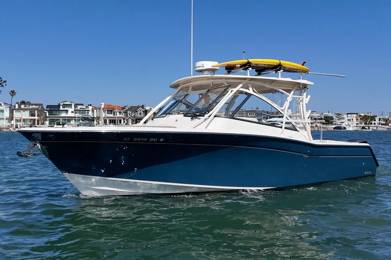 Slide: The Image of 2016 Grady-White Freedom 335 boat on water, with coastal homes in the background. - 6