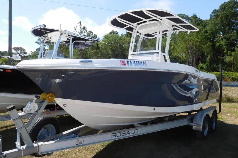 The Image of 2023 Robalo R202 Explorer boat on trailer, parked outdoors, side view. - 1