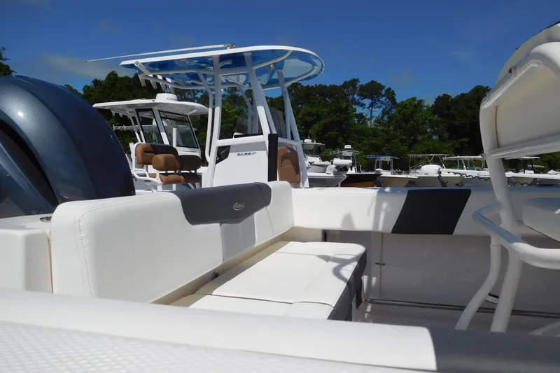 Slide: The Image of 2023 Robalo R202 Explorer boat interior with seating and console, docked outdoors. - 3