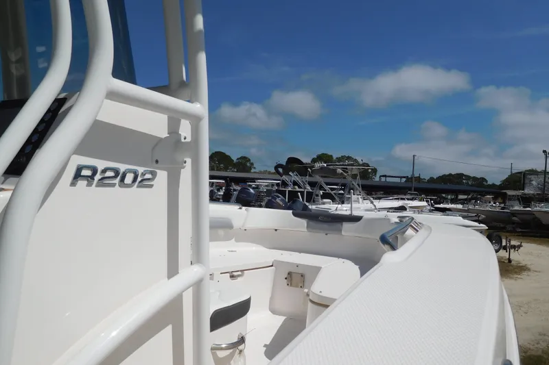 Slide: The Image of 2023 Robalo R202 Explorer boat in a marina under a clear blue sky. - 6