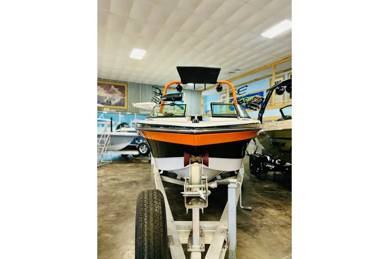 Slide: The Image of 2013 Nautique Super Air Nautique 230 boat on trailer in showroom. - 10