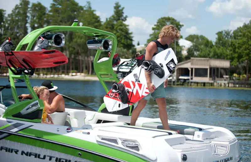 Slide: The Image of Manufacturer Provided Image: 2013 Nautique Super Air Nautique 230 with wakeboarders on a lake. - 8