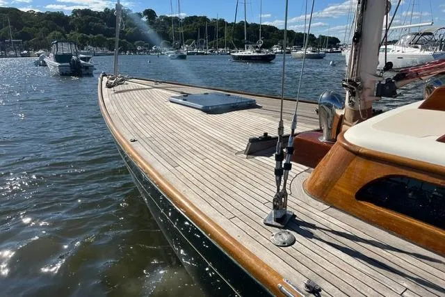 Slide: The Image of Sleek 2006 Morris 36 sailboat with wooden deck, docked in a serene marina. - 14