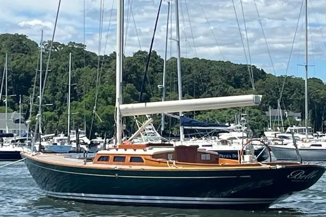 Slide: The Image of Sailboat Morris 36, 2006 model, docked in a marina with lush greenery background. - 2