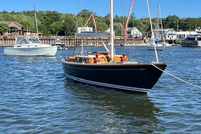 Slide: The Image of Sailboat on calm water, Morris 36 model, 2006, with scenic harbor background. - 9