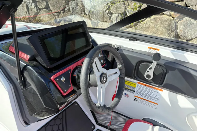 Slide: The Image of 2023 Scarab 215 ID boat dashboard with steering wheel and touchscreen display. - 11