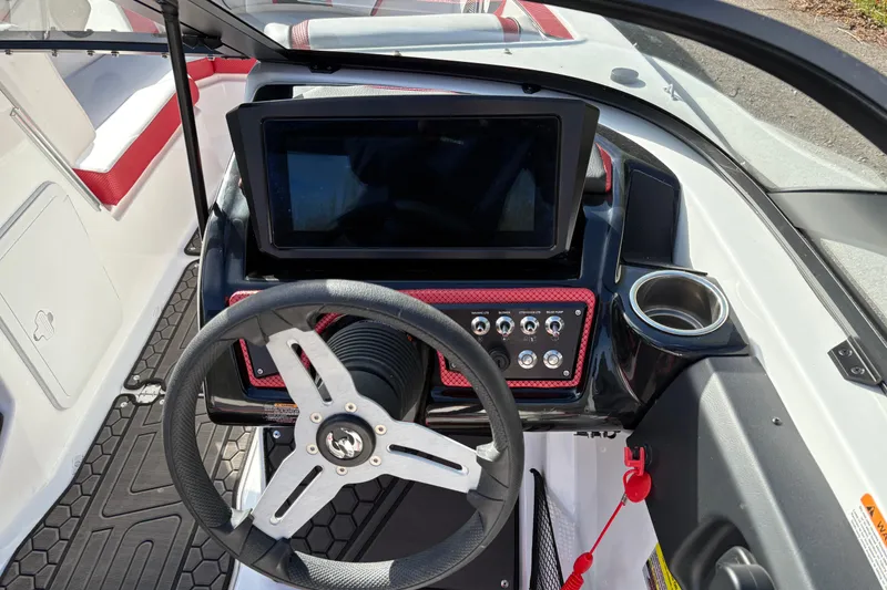 Slide: The Image of 2023 Scarab 215 ID boat dashboard with steering wheel and touchscreen display. - 12