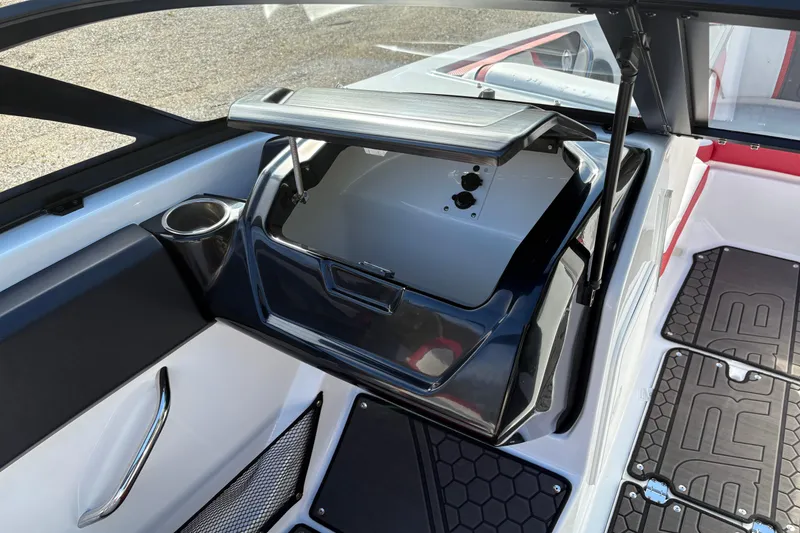 Slide: The Image of 2023 Scarab 215 ID boat interior with open storage compartment and cup holder. - 15