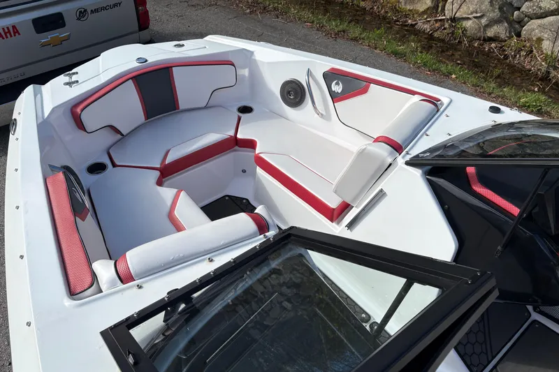 Slide: The Image of 2023 Scarab 215 ID boat interior with red and white seating, open windshield, and speaker. - 17