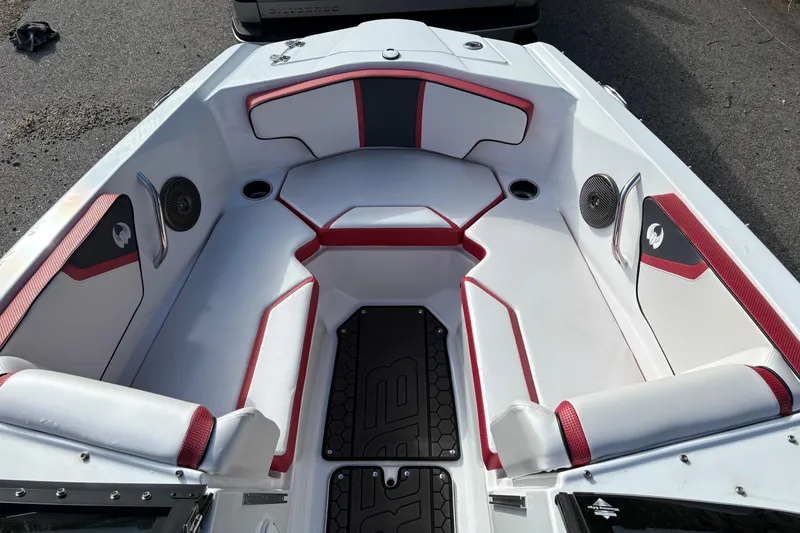 Slide: The Image of 2023 Scarab 215 ID boat interior with red and white seating, speakers, and sleek design. - 18