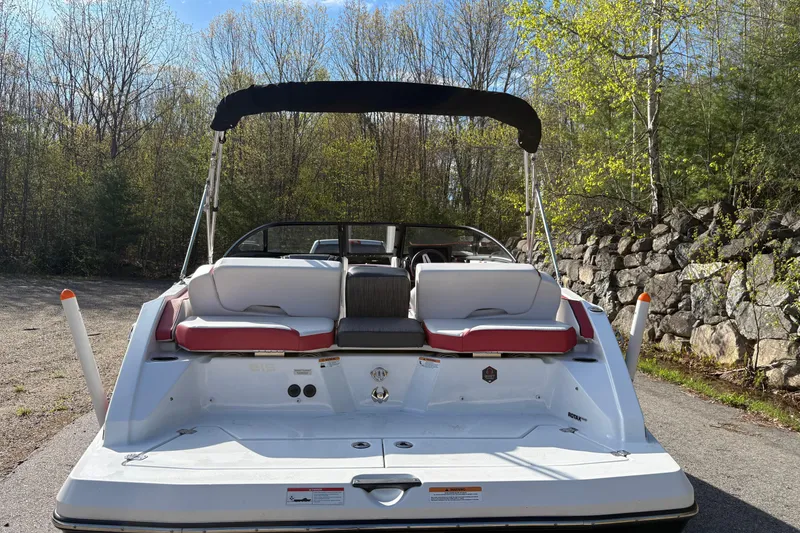 Slide: The Image of 2023 Scarab 215 ID boat with seating, parked outdoors near trees and rocks. - 4