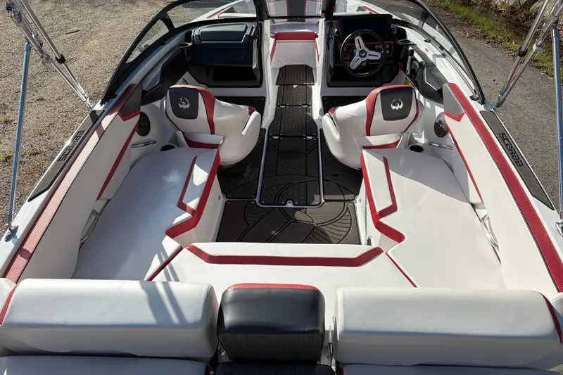 Slide: The Image of 2023 Scarab 215 ID boat interior with red and white seating, modern dashboard, and spacious layout. - 9
