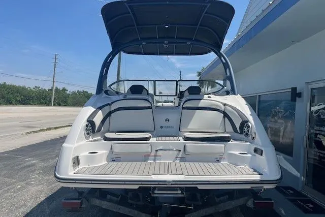 Slide: The Image of 2022 Yamaha 242SE boat with sleek design and spacious seating, parked outdoors. - 3