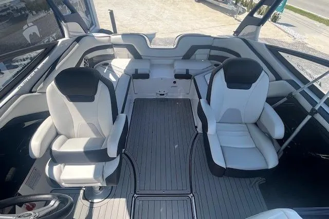Slide: The Image of 2022 Yamaha 242SE boat interior with dual captain's chairs and sleek design. - 7