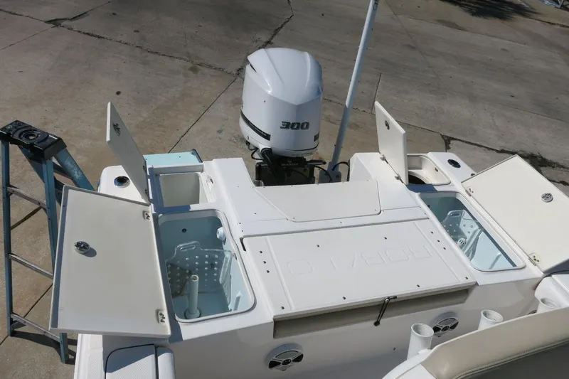 Slide: The Image of 2018 Robalo 246 Cayman boat with open storage compartments and powerful outboard motor. - 12