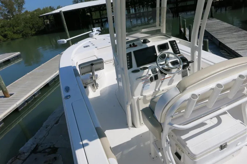 Slide: The Image of 2018 Robalo 246 Cayman boat interior with steering console and seating at dock. - 13