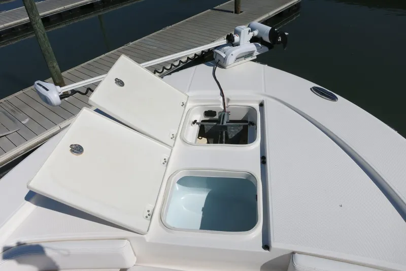 Slide: The Image of 2018 Robalo 246 Cayman boat deck with open storage compartments at dock. - 15