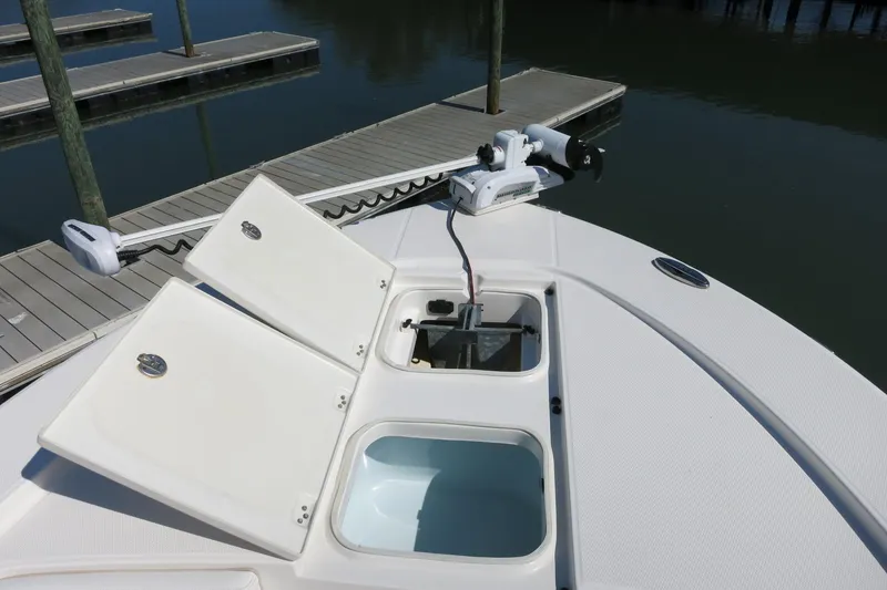 Slide: The Image of 2018 Robalo 246 Cayman boat deck with open storage compartments and trolling motor. - 16