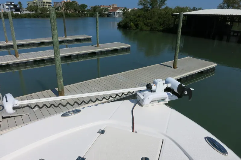 Slide: The Image of 2018 Robalo 246 Cayman boat docked at marina with trolling motor. - 17