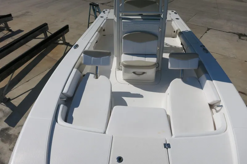 Slide: The Image of 2018 Robalo 246 Cayman boat interior with white seating and storage compartments. - 18