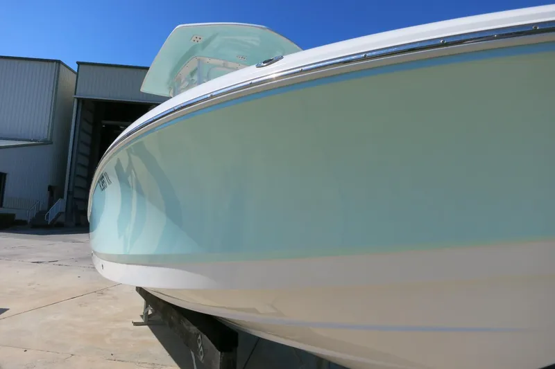 Slide: The Image of 2018 Robalo 246 Cayman boat in a marina, side view under clear blue sky. - 2